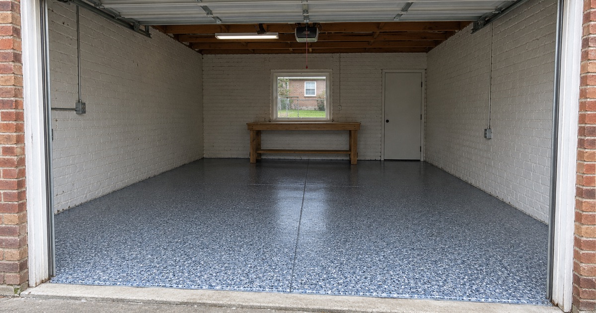 An empty finished flake floor in a detached Berwyn alley garage, handed back with the door raised.